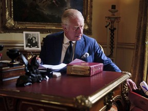 In this photo Sept. 11, 2022, taken Britain's King Charles III carries out official government duties from his red box in the Eighteenth Century Room at Buckingham Palace, London.