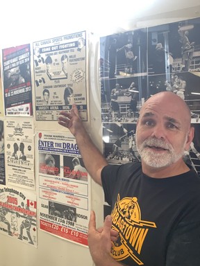 Johnny Kalbhenn, a longtime Cabbagetown Boxing Club trainer and former Olympian, points out an poster of himself.