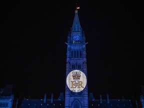 Parliament Hill is bathed in purple light and the Royal Cypher of Queen Elizabeth II is projected on the Peace Tower, following the death of Queen Elizabeth II, in Ottawa, on Thursday, Sept. 8, 2022.