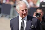 König Charles III. betrachtet am 9. September 2022 in London vor dem Buckingham Palace florale Ehrungen für die verstorbene Königin Elizabeth II.
