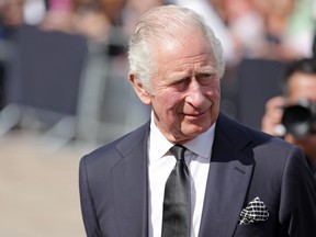 King Charles III views floral tributes to the late Queen Elizabeth II outside Buckingham Palace on Sept. 9, 2022 in London.