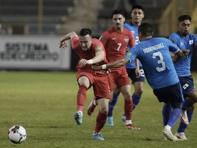 Canada's Liam Millar, left, and El Salvador's Roberto Dominguez, compete for the ball during a qualifying soccer match for the FIFA World Cup Qatar 2022 at Cuscatlan stadium in San Salvador, El Salvador, Wednesday, Feb. 2, 2022.