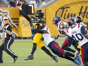 Hamilton Tiger Cats quarterback Matthew Shiltz (18) tries to throw to prevent the sack by Montreal Alouettes defensive back Adarius Pickett (6) during first half CFL football game action in Hamilton, Ont. on Thursday, July 28, 2022.