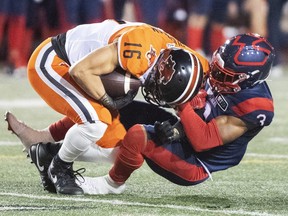 B.C. Lions' Bryan Burnham (16) is pulled down by Montreal Alouettes' Patrick Levels (3) during second half CFL football action against in Montreal, Saturday, September 18, 2021.