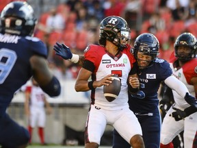 Ottawa Redblacks quarterback Caleb Evans (5) is sacked by Toronto Argonauts defensive lineman Shane Ray (5) during second quarter CFL action, in Toronto on Sunday July, 31, 2022.