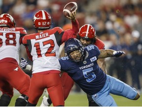Toronto Argonauts defensive lineman Shane Ray gets a tackle on Calgary Stampeders quarterback Jake Maier as he gets a throw off during second half CFL football action in Toronto on Saturday, August 20, 2022.