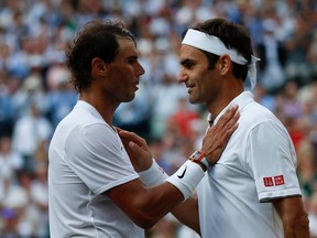 In this file photo taken on July 12, 2019 Switzerland's Roger Federer (R) speaks with Spain's Rafael Nadal (L) after Federer won their men's singles semi-final match on day 11 of the 2019 Wimbledon Championships at The All England Lawn Tennis Club in Wimbledon, southwest London.