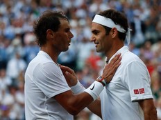 In this file photo taken on July 12, 2019 Switzerland's Roger Federer (R) speaks with Spain's Rafael Nadal (L) after Federer won their men's singles semi-final match on day 11 of the 2019 Wimbledon Championships at The All England Lawn Tennis Club in Wimbledon, southwest London.