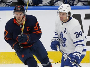 Dec 14, 2021; Edmonton, Alberta, CAN; Edmonton Oilers forward Connor McDavid and Toronto Maple Leafs forward Auston Matthews looks for a loose puck during the third period at Rogers Place.