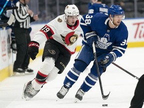 Jan 1, 2022; Toronto, Ontario, CAN; Toronto Maple Leafs defenseman Rasmus Sandin skates with the puck as Ottawa Senators right wing Drake Batherson gives chase during the second period at Scotiabank Arena.