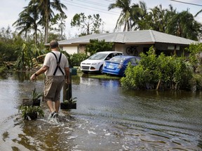 A resident walks back home on a flooded street following Hurricane Ian in Fort Myers, Fla., Thursday, Sept. 29, 2022.