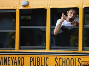 A man, who is part of a group of immigrants that had just arrived, flashes a thumbs up Wednesday Sept. 14, 2022, in Edgartown, Mass.