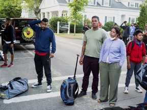 Immigrants gather with their belongings outside St. Andrews Episcopal Church in Edgartown, Mass., on Martha's Vineyard, Wednesday Sept. 14, 2022.