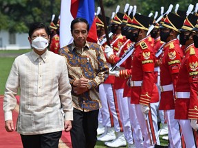 Philippine President Ferdinand Marcos Jr., left, escorted by Indonesian President Joko Widodo inspects an honour guard upon his arrival at the Presidential Palace in Bogor, West Java, Indonesia, Monday, Sept, 5, 2022.