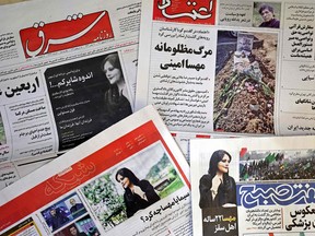 A picture take in Tehran on September 18, 2022 shows the front pages of Iranian newspapers featuring articles and photographs of Mahsa Amini.