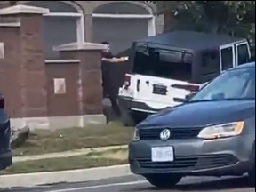 A screengrab from video posted to Twitter of a white Jeep driving erratically as a Peel cop tries to make an arrest.