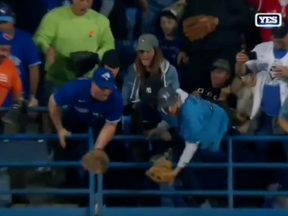 Two Blue Jays fans with gloves fail to catch the 61st home run ball hit by Aaron Judge at Rogers Centre.