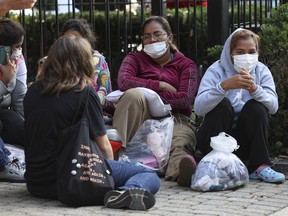 Migrants from Central and South America wait near the residence of U.S. Vice President Kamala Harris after being dropped off on September 15, 2022 in Washington.