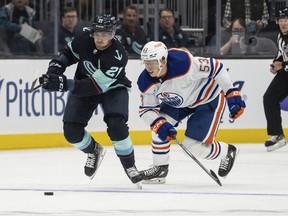 Seattle Kraken forward Alex Wennberg and Edmonton Oilers forward Reid Schaefer battle for the puck during the first period of a preseason NHL hockey game, Monday, Sept. 26, 2022, in Seattle.