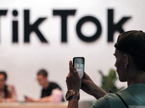 A visitor makes a photo at the TikTok exhibition stands at the Gamescom computer gaming fair in Cologne, Germany, Thursday, Aug. 25, 2022.
