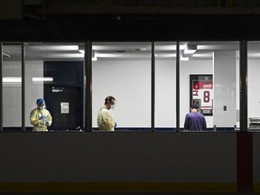 Health-care workers get ready to test a person at a pop-up COVID-19 assessment centre at the Angela James Arena during the COVID-19 pandemic in Toronto May 19, 2021.