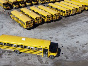 In this photo taken using a drone, school buses are seen in a lot in Ottawa on Monday, April 18, 2022.&ampnbsp;Officials are warning that school bus driver shortages and resulting delays and cancellations that often plague the start of the school year are being exacerbated by the pandemic, and may continue well into the fall semester in some areas of Ontario.