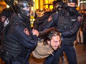 Russian police officers detain a man following calls to protest against partial mobilization announced by Russian President, in Moscow, on Sept. 21, 2022.