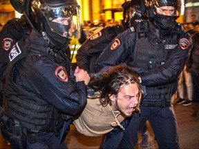 Russian police officers detain a man following calls to protest against partial mobilization announced by Russian President, in Moscow, Sept. 21, 2022.