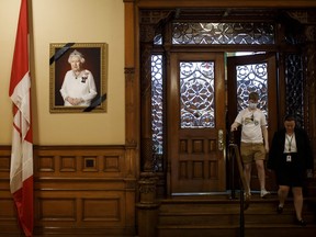 A portrait of Queen Elizabeth II is draped with a black ribbon as people take a tour of the Queen's Park Legislative Assembly of Ontario, on Sept. 9, 2022 in Toronto.