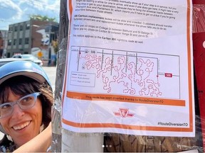 Artist Shari Kasman is pictured behind a pole bearing one of her faux "temporary route change" TTC flyers.