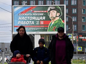 In this file photo taken on September 20, 2022 a billboard promoting contract army service with an image of a serviceman and the slogan reading "Serving Russia is a real job" sits in Saint Petersburg.