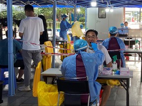 Medical workers in protective suits collect swabs at a nucleic acid testing site at the Software Park in Nanshan district, following a COVID-19 outbreak in Shenzhen, Guangdong province, China, Sept. 2, 2022.