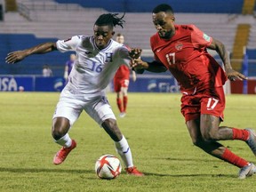 Honduras' Wisdom Quaye, left, and Canada's Cyle Larin fight for the ball during a qualifying soccer match for the FIFA World Cup Qatar 2022 in San Pedro Sula, Honduras, Jan. 27, 2022.