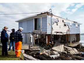 People examine the remains of a house after the arrival of Hurricane Fiona in Port Aux Basques, Newfoundland, Sept. 25, 2022.