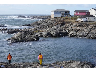 Search and rescue crew examine the coastline as they search for an individual swept out to sea after the arrival of Hurricane Fiona in Port Aux Basques, Newfoundland, Sept. 25, 2022.