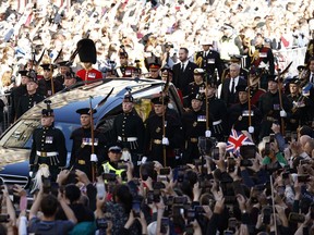 Crowd gather as the procession of Queen Elizabeth's coffin winds its way through the streets of Edinburgh, Scotland, Monday, Sept. 12, 2022.