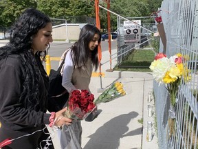 Roshani Zamany (right) and Maika Makki leave flowers outside an apartment building near Gilder Dr. and  Eglinton Av E for their friend and former classmate Zaybion Lawrence,17, who was shot to death on Wednesday, Sept. 21, 2022.