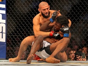 Khamzat Chimaev (red gloves) fights Kevin Holland (blue gloves) during UFC 279 at T-Mobile Arena.