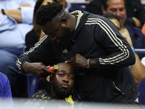 A fan gets his hair cut during the U.S. Open quarterfinal at USTA Billie Jean King National Tennis Center on September 6, 2022.