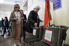 A refugee from Ukraine regions held by Russia casts a ballot for a referendum at a polling station in Rostov-on-Don on Sept. 24, 2022.