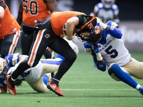 B.C. Lions quarterback Nathan Rourke (12) is sacked by Winnipeg Blue Bombers' Willie Jefferson (5) during the first half on Saturday night. (Darryl Dyck)