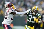 Aaron Jones of the Green Bay Packers stiff arms Devin McCourty of the New England Patriots.