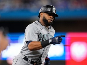 Seattle Mariners designated hitter Carlos Santana gestures as he rounds the bases on a three-run home run in the sixth inning against the Toronto Blue Jays.