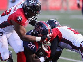 Montreal Alouettes running back Jeshrun Antwi (20) his tackled by Ottawa Redblacks's Avery Williams (42) during second half CFL action in Montreal on Monday October 10, 2022.