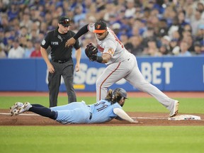 Jesus Aguilar #99 of the Baltimore Orioles records the last out of a triple play on Bo Bichette #11 of the Toronto Blue Jays at first base in the third inning at the Rogers Centre on September 18, 2022 in Toronto, Ontario, Canada.