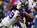 J.K. Dobbins of the Baltimore Ravens runs with the ball while being tackled by Tremaine Edmunds of the Buffalo Bills in the first quarter  at M&T Bank Stadium on October 02, 2022 in Baltimore, Maryland.