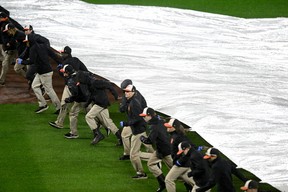 The grounds crew puts the tarp on the field in the eighth inning between the Toronto Blue Jays and the Baltimore Orioles at Oriole Park at Camden Yards on Monday, Oct. 3, 2022 in Baltimore, Maryland. GREG FIUME/GETTY IMAGES