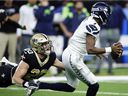 Geno Smith of the Seattle Seahawks is taken down by Pete Werner of the New Orleans Saints during the second half of the game at Caesars Superdome on October 09, 2022 in New Orleans, Louisiana.