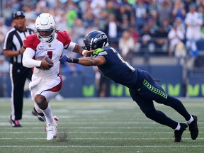 Kyler Murray of the Arizona Cardinals is tackled by Coby Bryant of the Seattle Seahawks during the third quarter at Lumen Field on October 16, 2022 in Seattle, Washington.