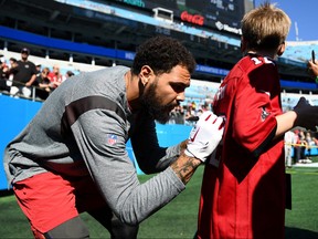 Mike Evans of the Tampa Bay Buccaneers signs a young fans jersey prior to the game against the Carolina Panthers at Bank of America Stadium on October 23, 2022 in Charlotte, North Carolina.